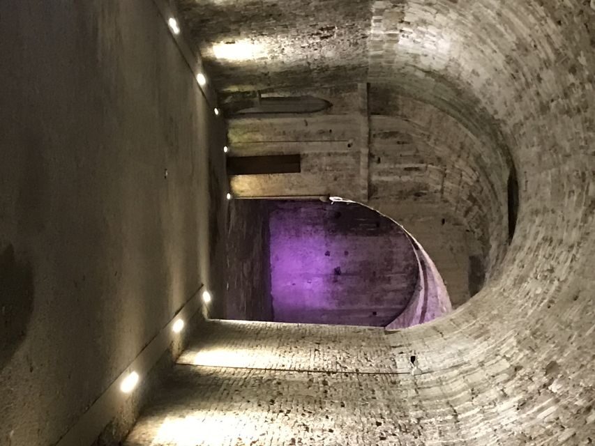 Lucca: Guided City by Night Walking Tour - San Michele Basilica: lit sculpture on top of a Roman past